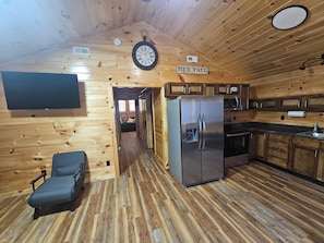 A wooden interior with a kitchen, a clock, and a sign that reads 'HEY YALL'. - Charming 2-bedroom barn in pleasant LaFayette with AC (LaFayette)