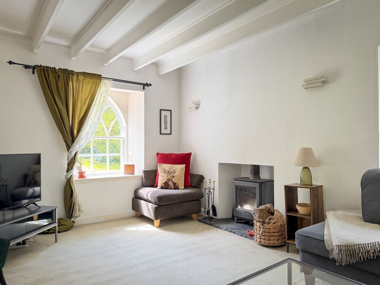 A cozy living room with a fireplace, a television, and a comfortable sofa.