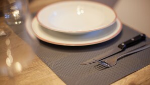 A dining table with a plate, a knife, and a fork. - Bus  The Station Apartments (Durrës)
