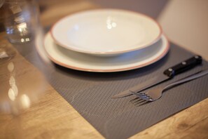 A dining table with a plate, a knife, and a fork. - Bus  The Station Apartments (Durrës)