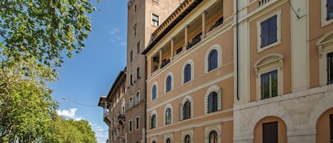 Un edificio de varios pisos con balcones, ventanas amplias y cielo despejado.