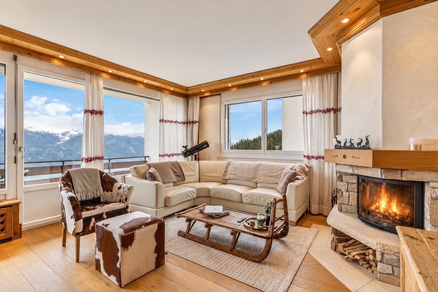 A cozy living room with a fireplace, a large window with a mountain view, and a comfortable seating area.