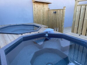 Ein Whirlpoolbereich mit Holzboden und Holzzaun.