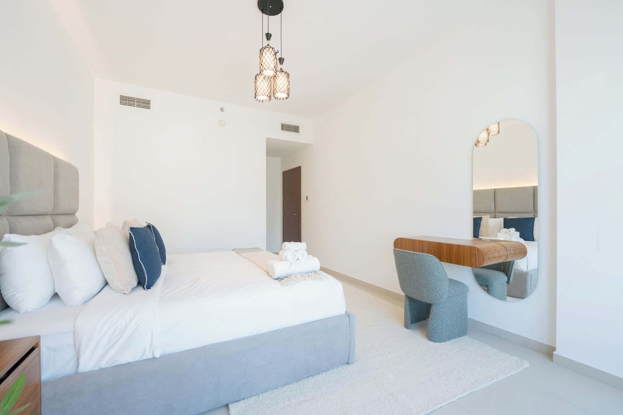 Ein modernes Schlafzimmer mit Bett, Nachttisch und Spiegel.