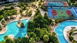 A swimming pool surrounded by palm trees and a basketball court. - Modern 1BR Living at Reem Island by Vanilla Homes (Abu Dhabi)