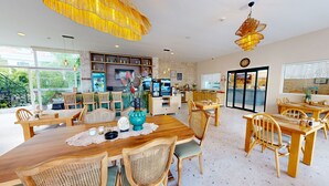 A spacious dining area with wooden furniture, a bar area with shelves of bottles, and large windows offering views of the outdoors. - del Mare Hotel Ölüdeniz (Fethiye)