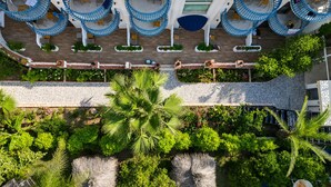 A multi-level hotel with outdoor seating areas, a covered walkway, and lush greenery. - del Mare Hotel Ölüdeniz (Fethiye)