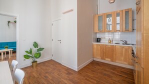 Moderni keittiö, jossa on puiset kaapit, työtaso ja riippuvalaisin.