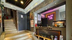 A reception area with a neon sign, a staircase, and a sign prohibiting smoking. - Nova Park Suites (İstanbul)