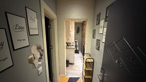 A hallway with framed motivational quotes, a hexagonal light fixture, and a patterned rug. - Nova Park Suites (İstanbul)