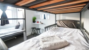 A bunk bed room with a wooden ceiling, a small desk, and a window with curtains. - Aura - Sleeps 6 - Free Parking (Folkestone)