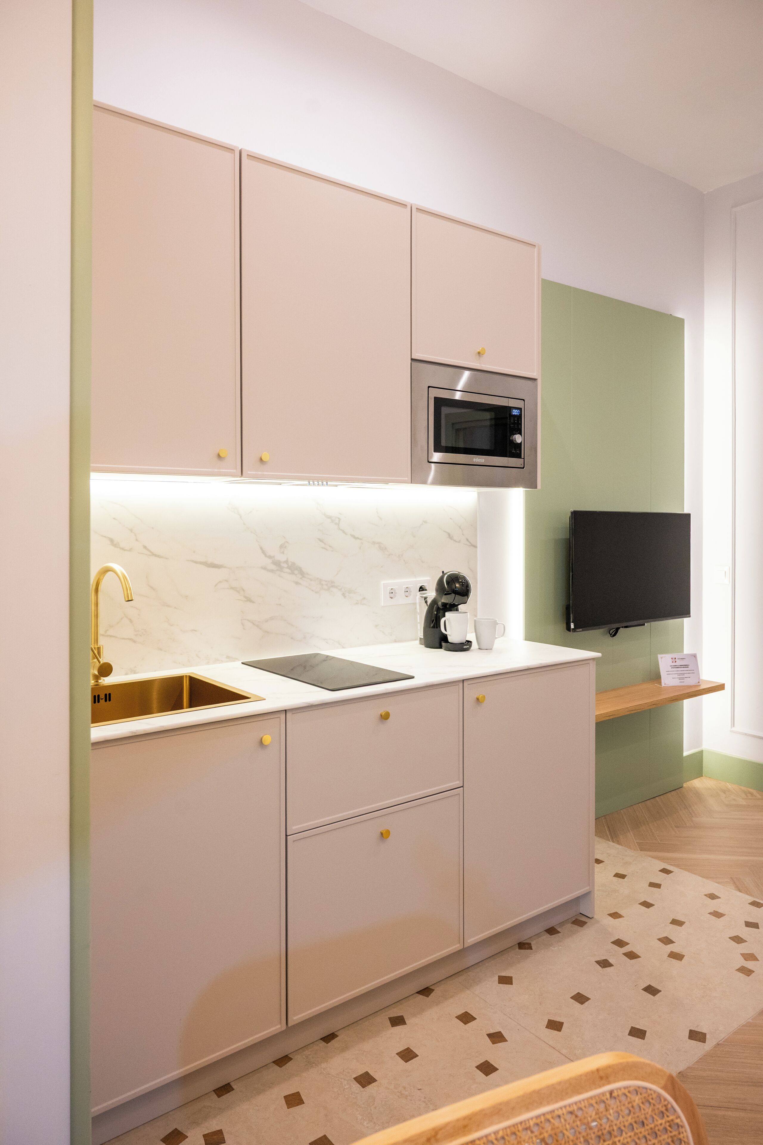 A modern kitchen with a built-in microwave, a sink, and a coffee maker.