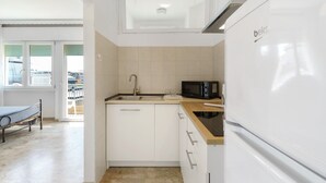 Una cocina compacta equipada con fregadero, microondas y refrigerador.