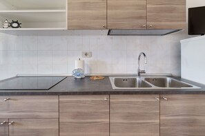 Eine moderne Küche mit Holzschränken, einer doppelten Spüle und einer schwarzen Arbeitsplatte.