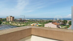 A balcony with a view of a Ferris wheel, a beach, and a playground. - Just Steps from the Beach – Cozy Apartment in Sottomarina (Chioggia)