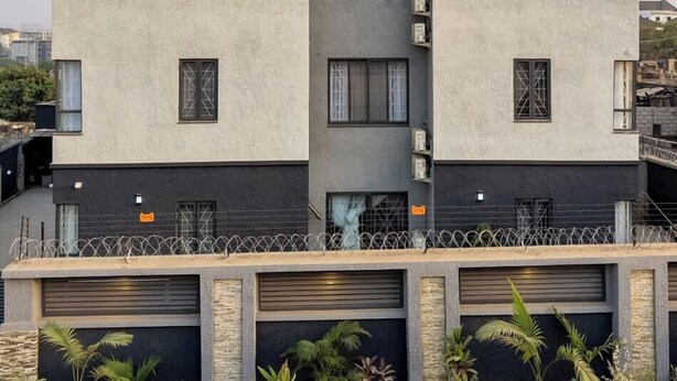 A modern two-story building with a symmetrical facade, large windows, and a visible garage area. - 168 Apartments (Abuja)