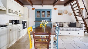 Eine Küche mit weißen Schränken, einem Holztisch und einem blauen Schrank.