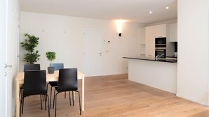 A modern kitchen with white cabinets, a black countertop, and a microwave. - 12-guest Apartment on the Main Square (Antwerp)