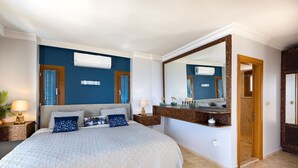 A bedroom with a bed, bedside tables, a large mirror, and an air conditioning unit. - Yalıkavakta 3 Odalı Villa BD4148 (Bodrum)