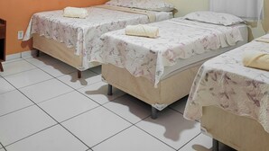 Una habitación con dos camas, aire acondicionado, una cortina y piso de baldosas.