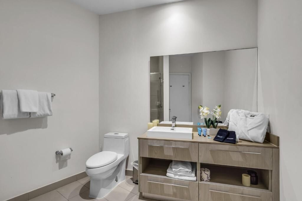 Une salle de bain moderne équipée de toilettes, d’un lavabo et d’un meuble-lavabo.