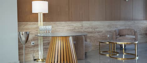 Een modern interieur met een ronde tafel, een lamp, een bank en een stoel.