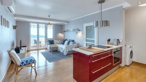 A modern apartment with a kitchen, dining area, and a living room.