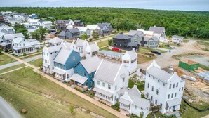 A residential area with houses, a driveway, and a green landscape. - North Gable- Bunkhouse in Steele Park with Private Pool and Hot Tub access (Carlton Landing)