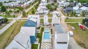 Ett bostadsområde med hus, en swimmingpool och en väg.