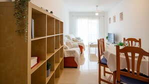 A living room with a sofa, wooden shelves, a dining table, and chairs. - Andaluc a Sun Duplex Torrox-costa (Torrox)