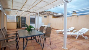 A covered patio with a table and chairs, a potted plant, and a view of the cityscape. - Andaluc a Sun Duplex Torrox-costa (Torrox)