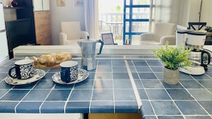 A kitchen with a coffee maker, two cups, and a plant on the counter. - Edificio Arrecife Primera L nea Vistas al Mar y (Torrox)