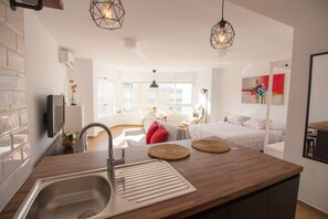 A modern kitchen with a sink, wooden countertop, and hanging lights. - Madrid 810 by At Home Costa del Sol (Torrox)