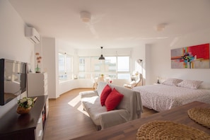 A modern bedroom with a bed, a sofa, a TV, and a large window. - Madrid 810 by At Home Costa del Sol (Torrox)