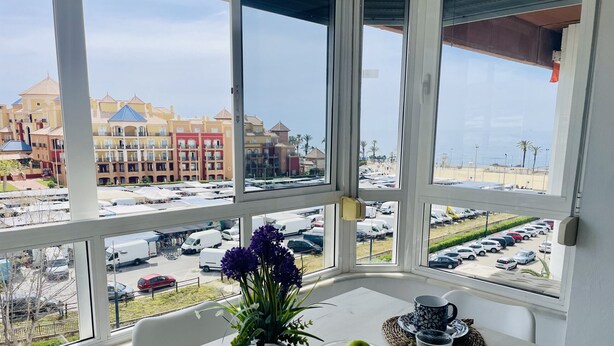 Ein Zimmer mit großem Fenster mit Blick auf einen Parkplatz und Gebäude.
