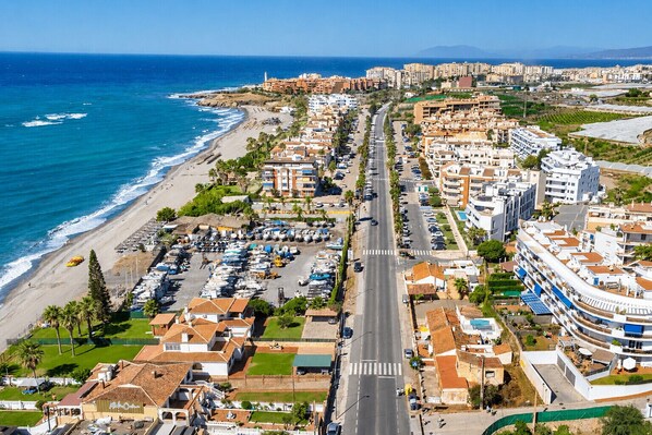 An aerial view of a coastal town with a beach, a main road, and residential buildings. - Andalusia Sun Duplex | Torrox-Costa (Torrox)