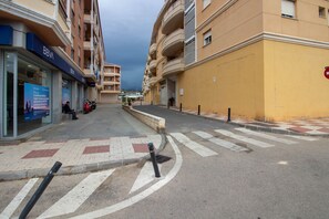 A street with a pedestrian crossing, a BBVA bank, and a yellow building. - Andalusia Sun Duplex | Torrox-Costa (Torrox)