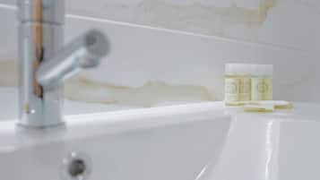Un lavamanos con grifo y pared de mármol.