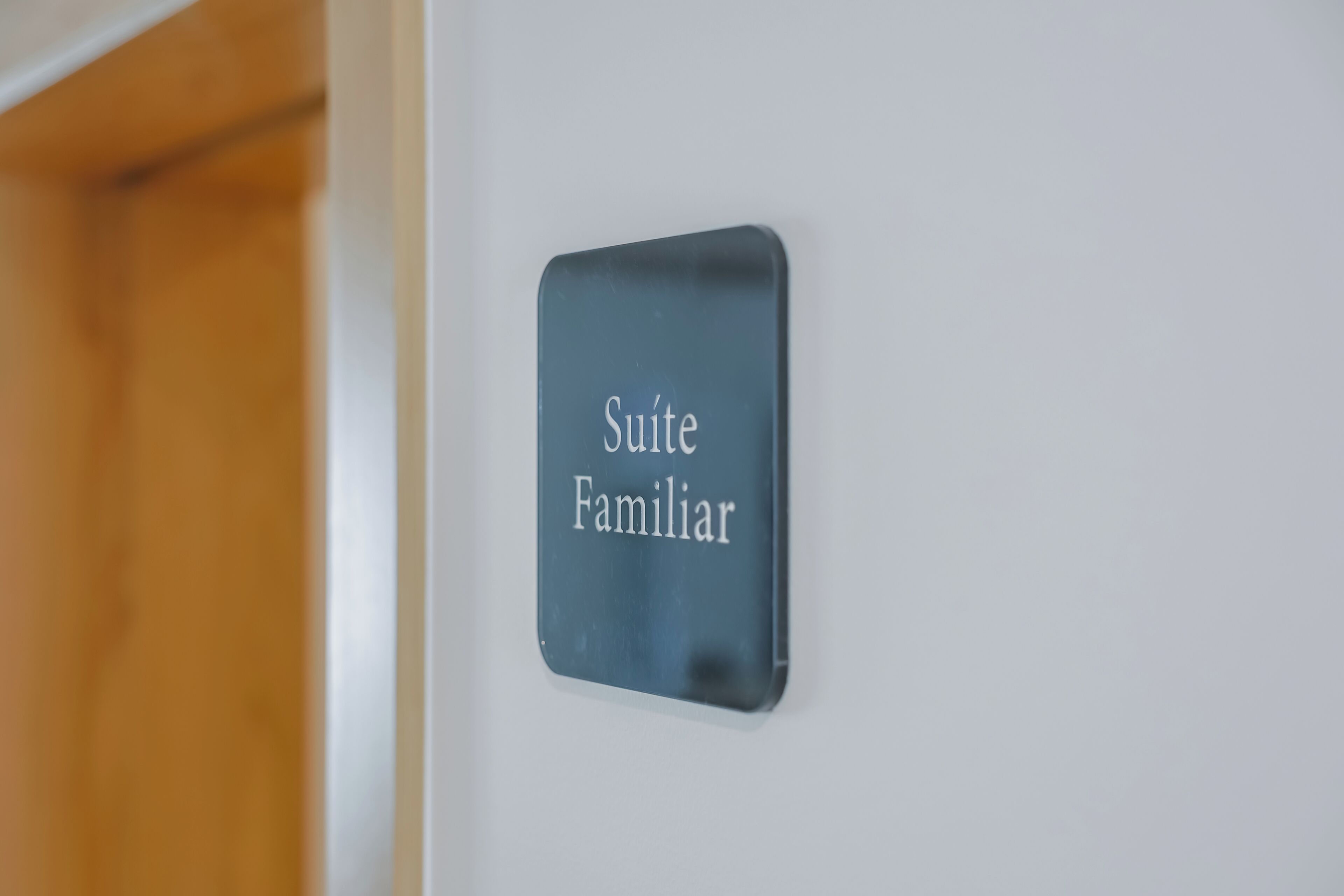 Ein Schild mit der Aufschrift 'Suite Familiar' an einer weißen Wand.