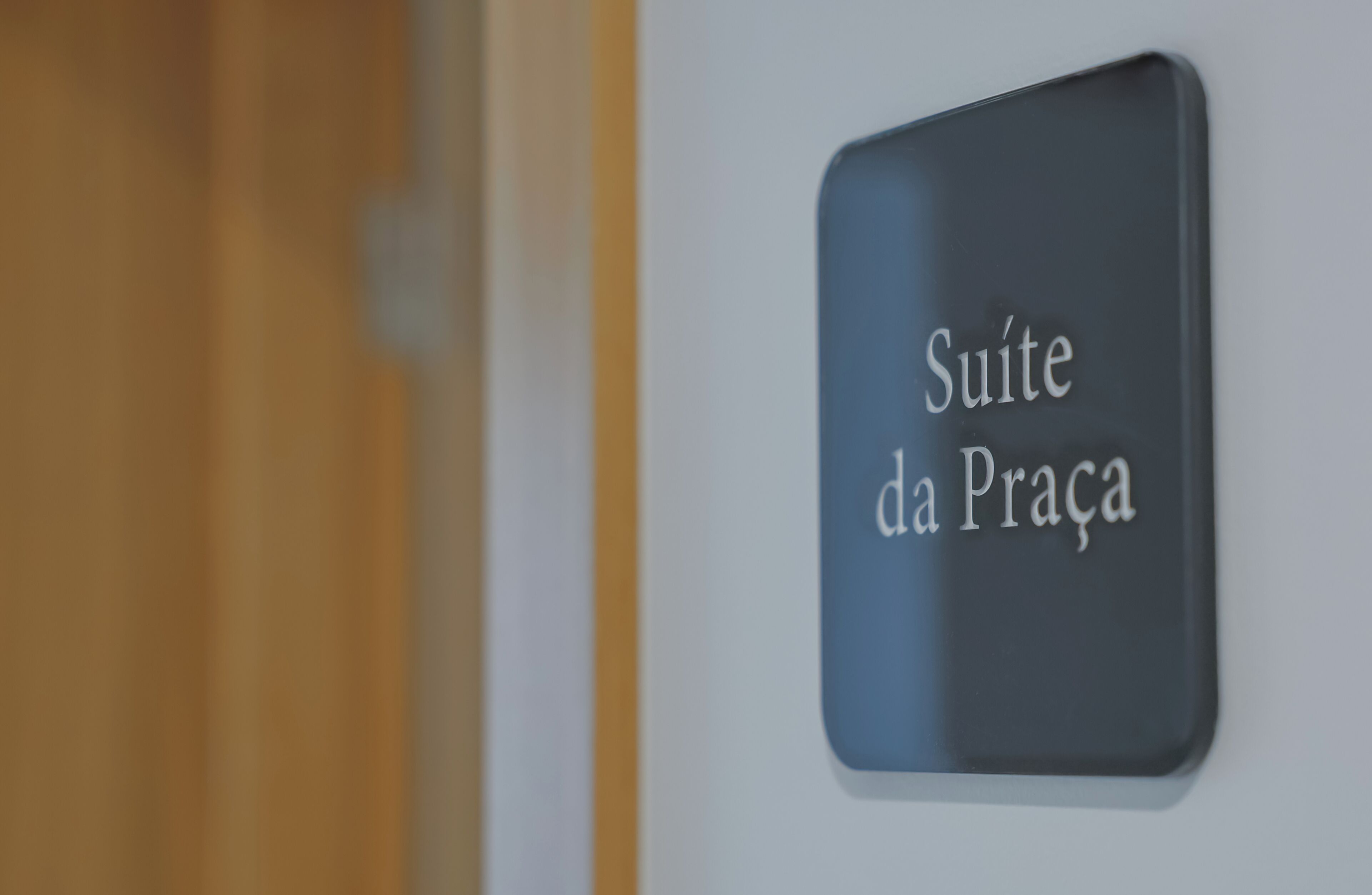 Une pancarte portant l’inscription « Suite da Praça », indiquant une chambre ou une suite particulière dans un bâtiment.