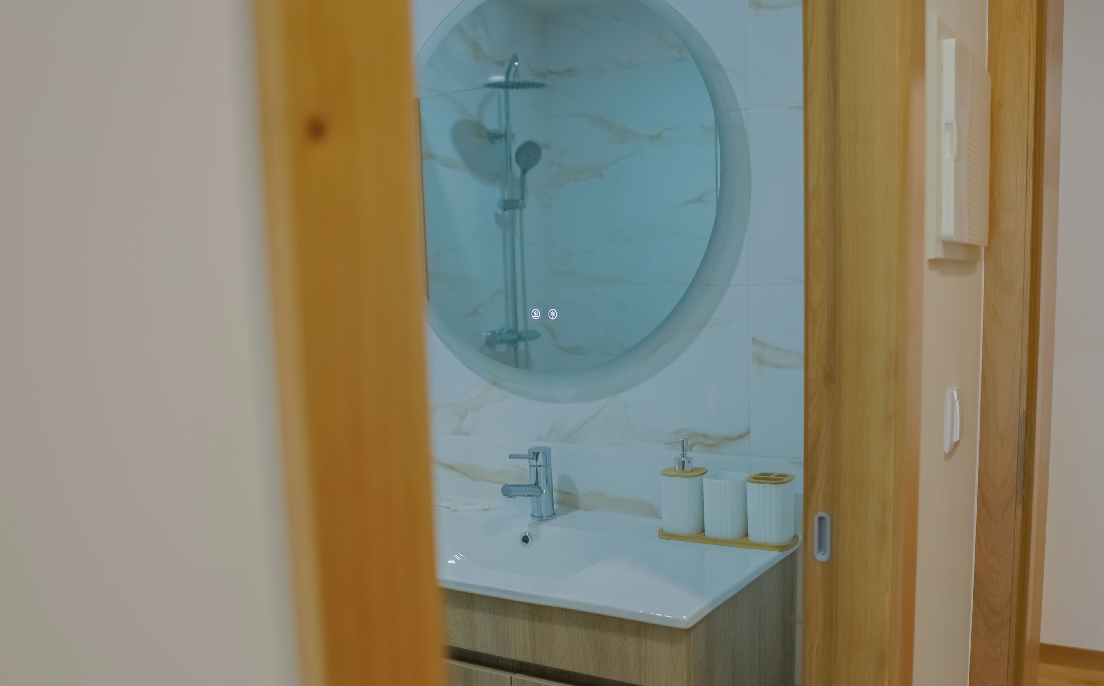 Un baño con un espejo grande, ducha e instalaciones de aseo.