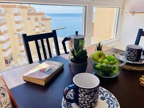 A table with a book, a bowl of grapes, a mug, and a potted plant. - Carabela 818 by At Home Costa del Sol (Torrox)