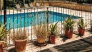 Ein Poolbereich mit Holzterrasse, Kübelpflanzen und Blick auf die Landschaft.
