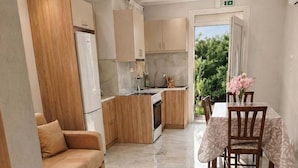Una cocina moderna con armarios de madera, una mesa de comedor con sillas y un sofá.