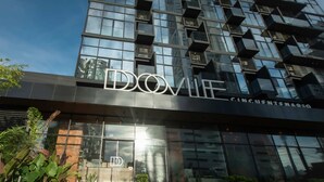 Um edifício moderno com fachada de vidro e o nome 'DOVIL' em destaque.