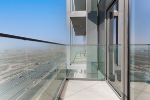 A high-rise building with a glass balcony overlooking a highway. - Free Housekeeping Visits During Your Stay - Stayshort - Majestic Studio in Bloom Tower C Perfect for 3 (Dubai)