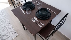 A dining table set with plates, glasses, cutlery, and a napkin. - Free Housekeeping Visits During Your Stay - Stayshort - Majestic Studio in Bloom Tower C Perfect for 3 (Dubai)