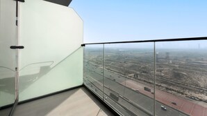 A high-rise building with a glass balcony overlooking a highway. - Free Housekeeping Visits During Your Stay - Stayshort - Majestic Studio in Bloom Tower C Perfect for 3 (Dubai)