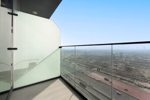Ein Hochhaus mit einem Glasbalkon mit Blick auf eine Autobahn.