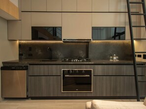 Cozinha moderna com eletrodomésticos embutidos, lava-louças e bancada de madeira.